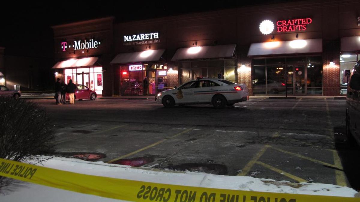 Men talk outside the Columbus, Ohio, restaurant where police say a man attacked several people with a machete on Thursday, Feb. 11, 2016. Authorities say the man fled the scene and was later fatally shot by police.