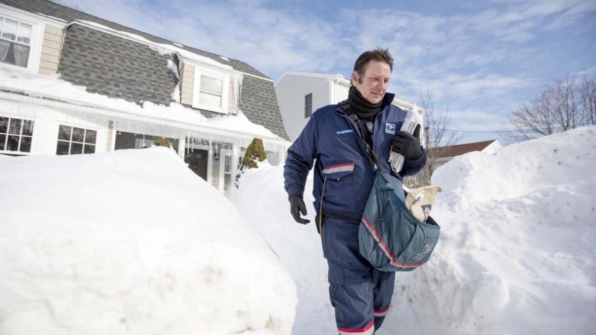 Letter carrier John Bachman walks between high snow banks after delivering mail to a house in Hull, Mass., in February. According to the U.S. Postal Service, which on Wednesday released its annual report on the topic, 6,549 postal workers were attacked by dogs in 2015, an increase of 14 percent from the year before.