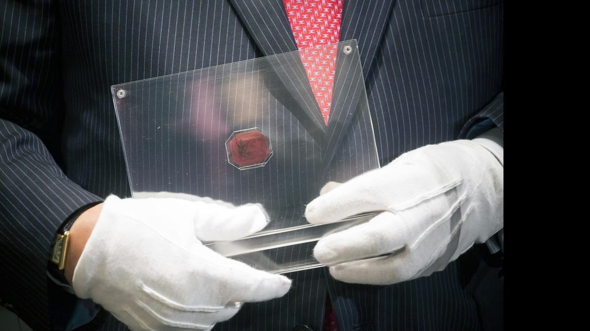 
David Redden holds an 1856 One-Cent Magenta stamp from British Guiana, which sold for a record $9.5 million at Sotheby's, in New York, June 17, 2014. 
