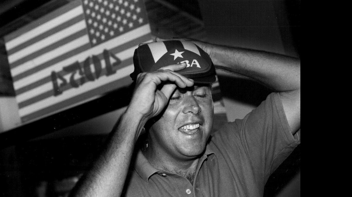 
Jeb Bush tries on a Cuban hat given to him by Pedro Garcia just before going through some Hialeah neighborhoods to canvas votes for his dad George Bush on Oct. 25, 1992.
