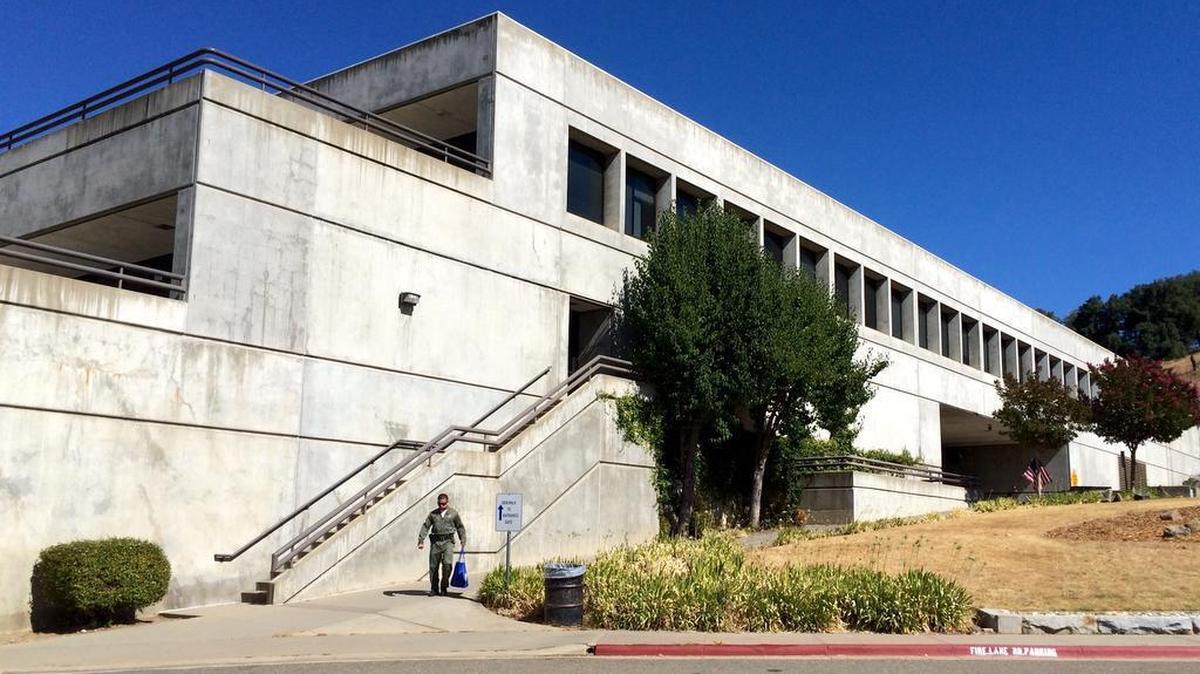 
A corrections officer walks outside a building Wednesday at California State Prison, Sacramento, in Folsom, where a prisoner riot killed one and injured at least 11. 
