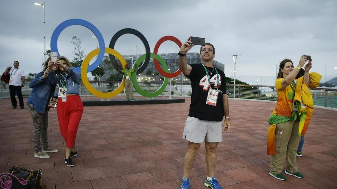 People take selfies in front the Olympic rings at Olympic Park ahead of the Summer Olympics in Rio de Janeiro in August. A new study has found a link between looking at too many selfies to decreased self-esteem and life satisfaction.