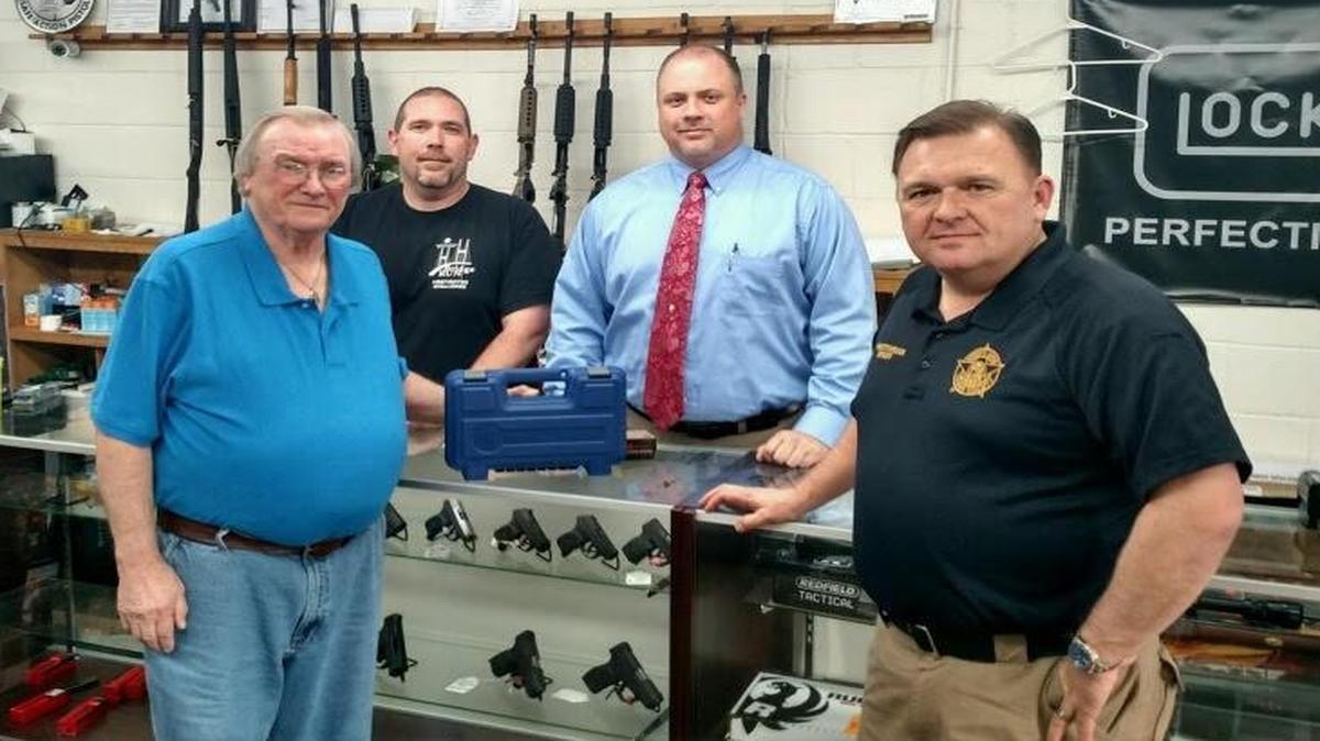 Billy Harrell, left, picks up a new .38 Smith & Wesson from CL Defense owners Lamar Marshall and Chris Ellis, pictured Wednesday at the store in McRae with Telfair County Sheriff Chris Steverson, right.