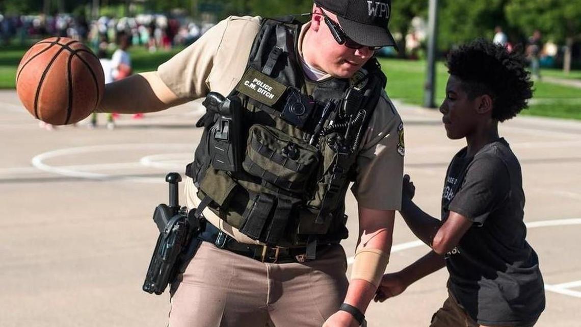 Wichita police Officer Chad Ditch plays basketball with Carlos Hernandez during the Black Lives Matter barbecue at McAdams Park on Sunday evening, July 17, 2016.