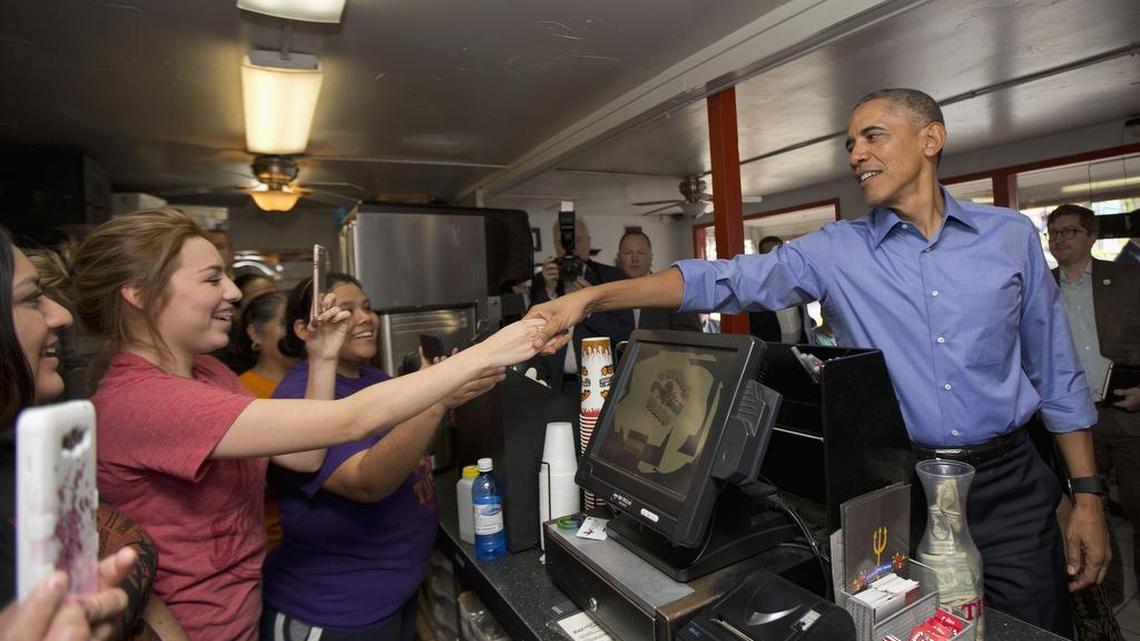President Barack Obama reaches over the counter to greet employees during an unannounced stop at Torchy’s Tacos on Friday, March 11, 2016, in Austin, Texas. Obama traveled to Austin, to speak at South by Southwest Festival (SXSW) and attend two Democratic National Committee fundraisers.