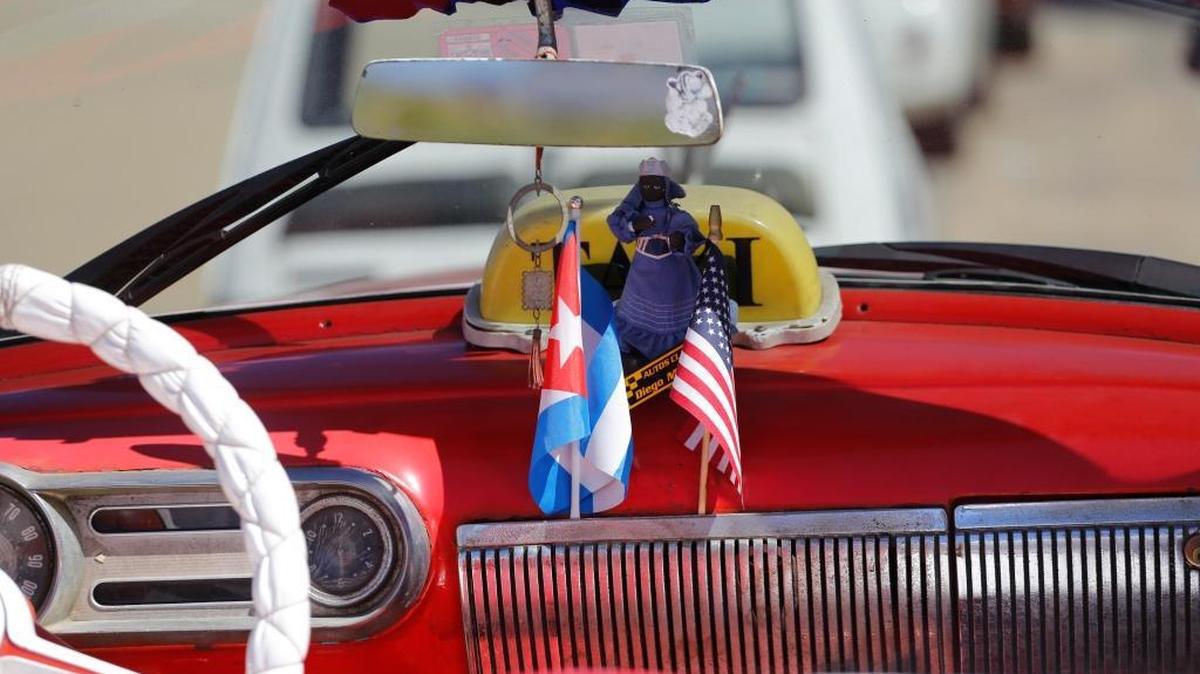 The stars and stripes and the Cuban national flag are placed together on the dashboard of a vintage American convertible in Havana, Cuba, on Thursday, Feb. 18, 2016. President Barack Obama said that he would visit Cuba on March 21-22, making him the first sitting president in more than half a century to visit the island nation.