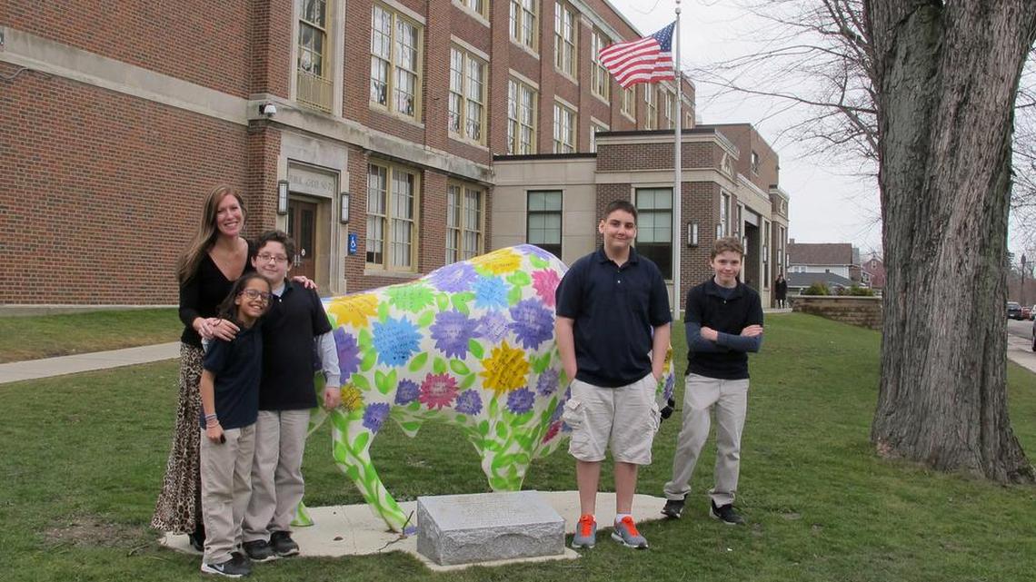 Teacher Kelly Gasior, left, and students, from left, Olivia Mashtaire, Ryan Lysek, Christian Vazquez and Tyler Lysek stand with a statue of a Buffalo that's been emblazoned with anti-bullying messages outside Lorraine Academy, Public School No. 72, in Buffalo, N.Y. Educators in Buffalo and elsewhere worry the name-calling, mocking and social media attacks that have gotten applause in the presidential campaign could undermine schools' bullying prevention policies that call for kindness and respect.