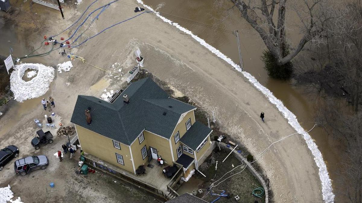 In this aerial photo, a person walks atop a temporary levee protecting Kimmswick, Mo., from the Mississippi River, Dec. 31, 2015. Surging Midwestern rivers forced hundreds of evacuations, threatened dozens of levees and brought transportation by car, boat or train to a virtual standstill Thursday in the St. Louis area.