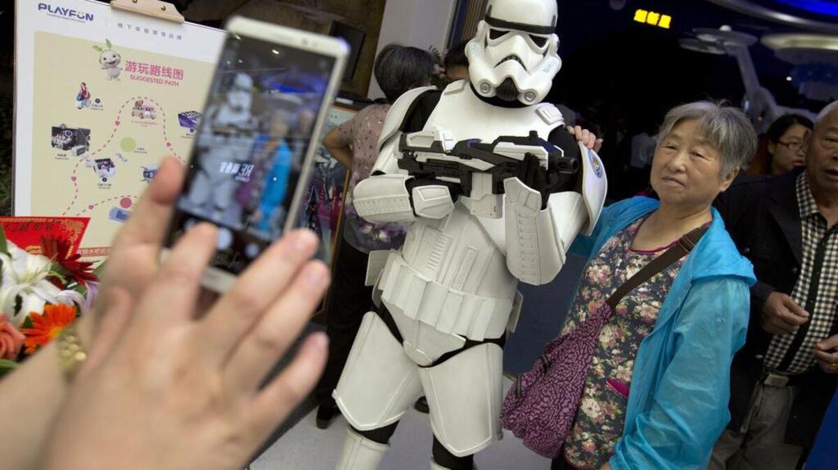 A woman poses for a smartphone photo with a person dressed in a stormtrooper costume in southeastern China’s Jiangxi province.