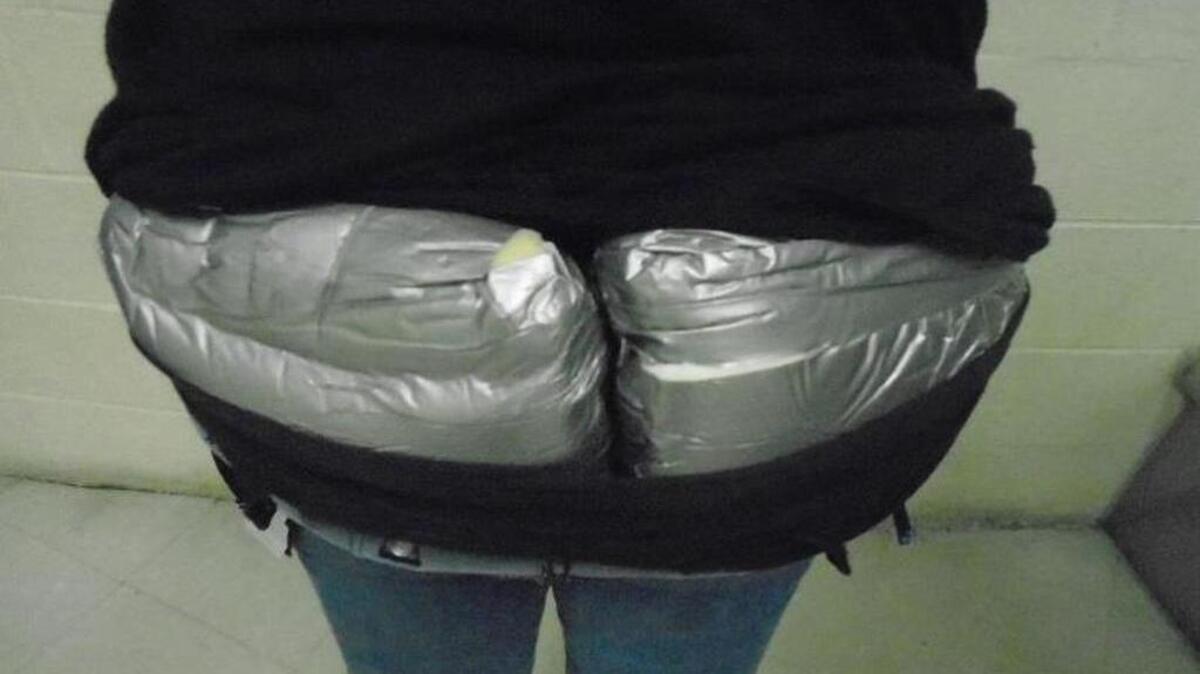 A woman tried to smuggle three pounds of heroin into the country by hiding the drugs in the back of her pants.