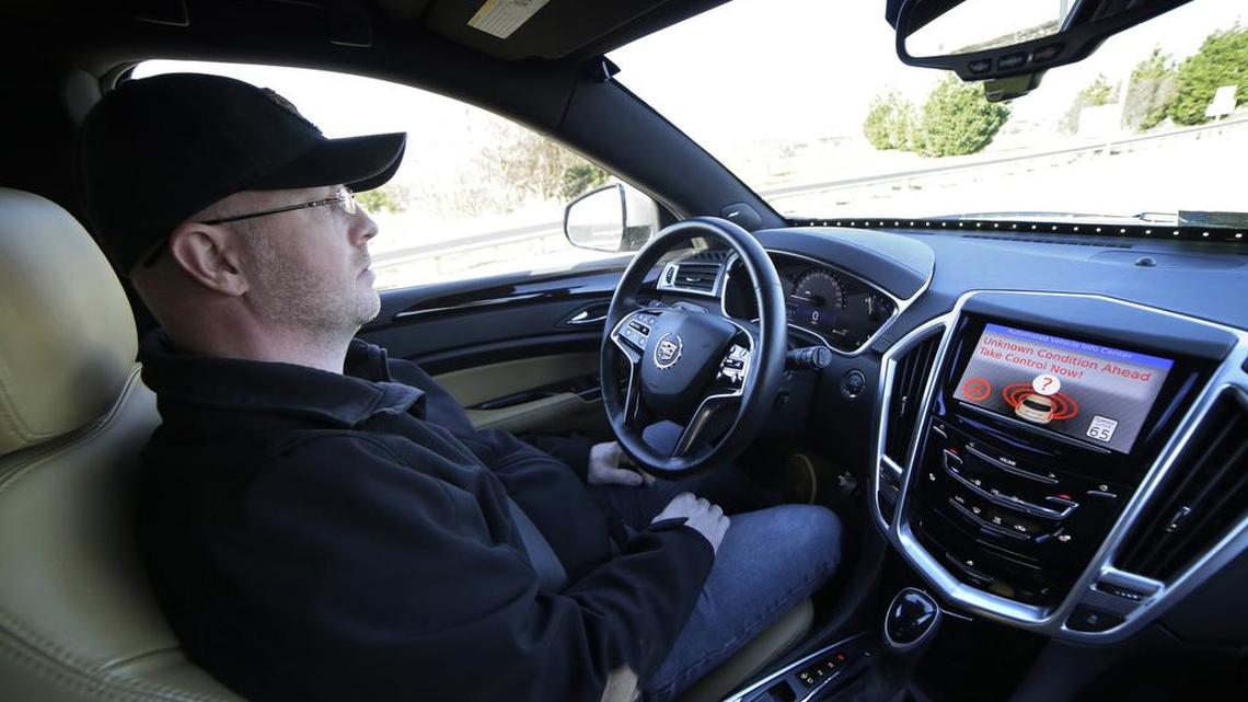 This photo provided by Virginia Tech shows Greg Brown, technology development program administration specialist, behind the wheel of a self-driving car during a test ride on a street in Blacksburg, Va.