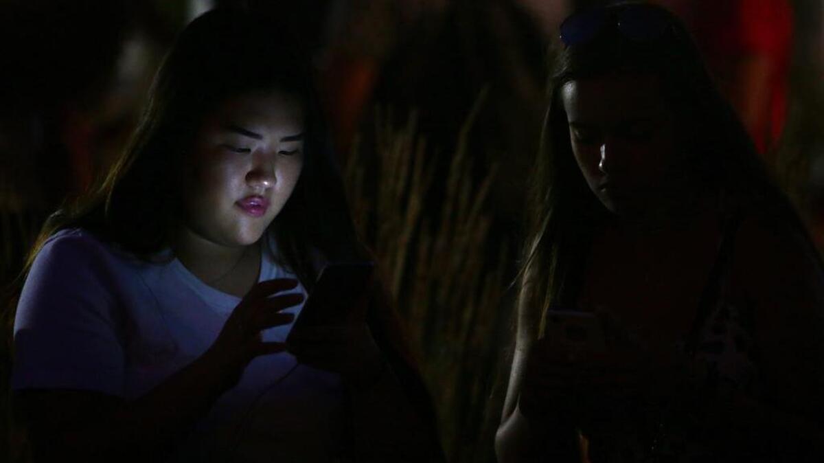A gamer's face is illuminated during a "Pokemon Go" smartphone game release party in Toronto, Monday, July 18, 2016.