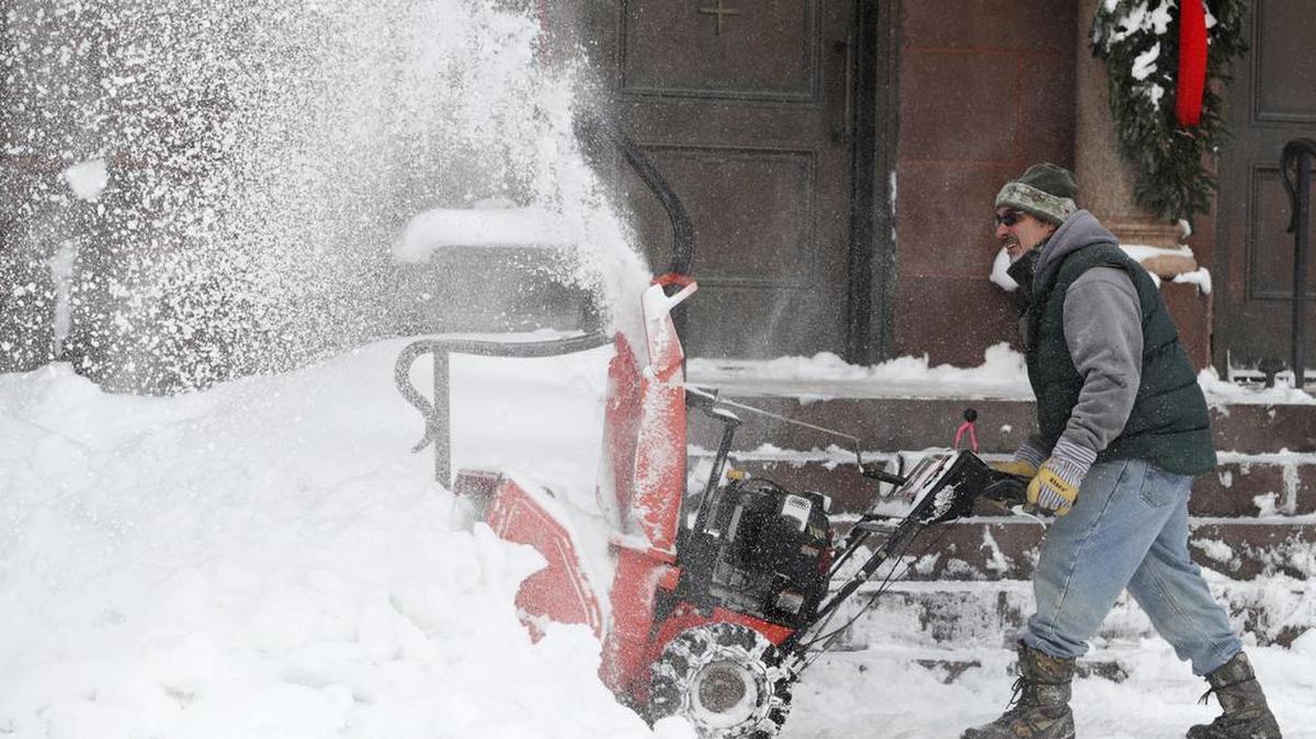 Frank Necci clears snow from St. Andrews Catholic Church, Friday, Dec. 29, 2017, in Erie, Pa.