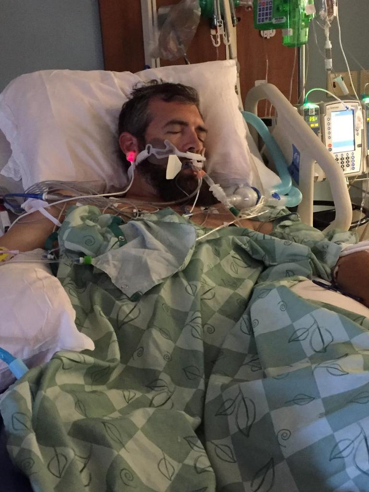 John Ogburn lies in a hospital bed at Novant Health Presbyterian Medical Center on June 27, the day after he went into cardiac arrest.