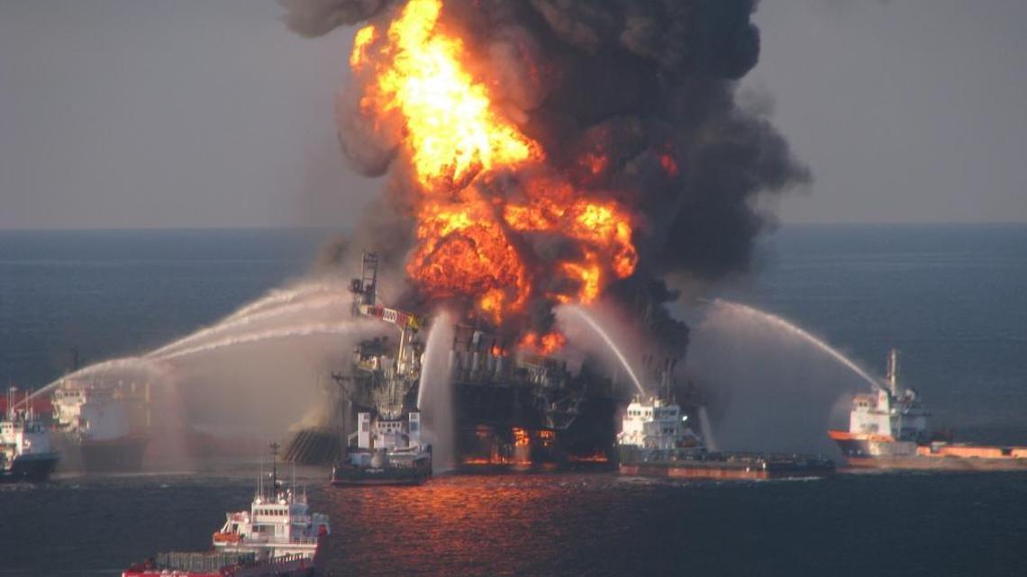Fire boat response crews battle the blazing remnants of the offshore oil rig Deepwater Horizon on April 21, 2010. A Coast Guard MH-65C dolphin rescue helicopter and crew document the fire aboard the mobile offshore drilling unit Deepwater Horizon, while searching for survivors. Multiple Coast Guard helicopters, planes and cutters responded to rescue the Deepwater Horizon’s 126-person crew.