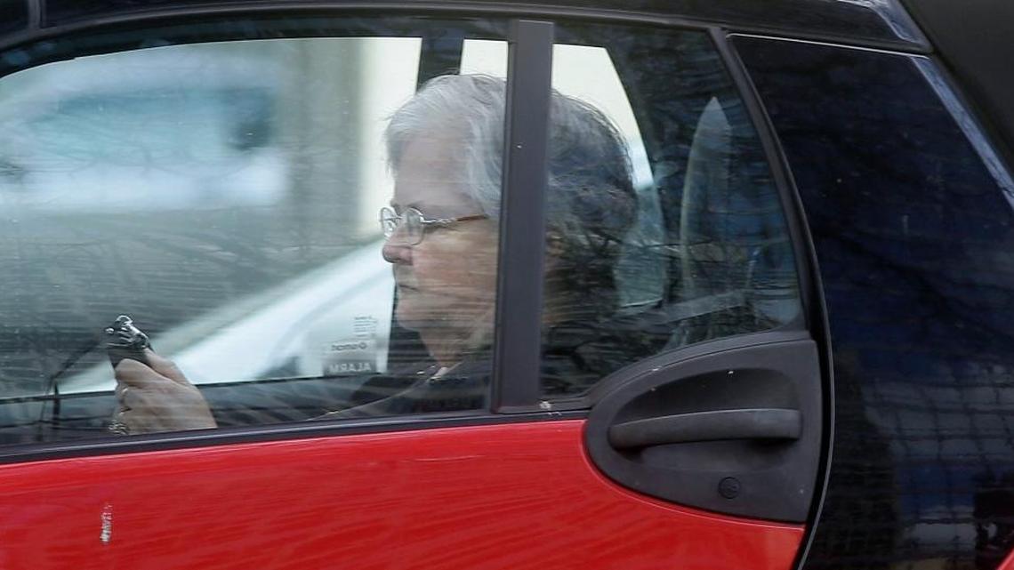 A driver looks at her phone while making her way through traffic in Dallas last spring.