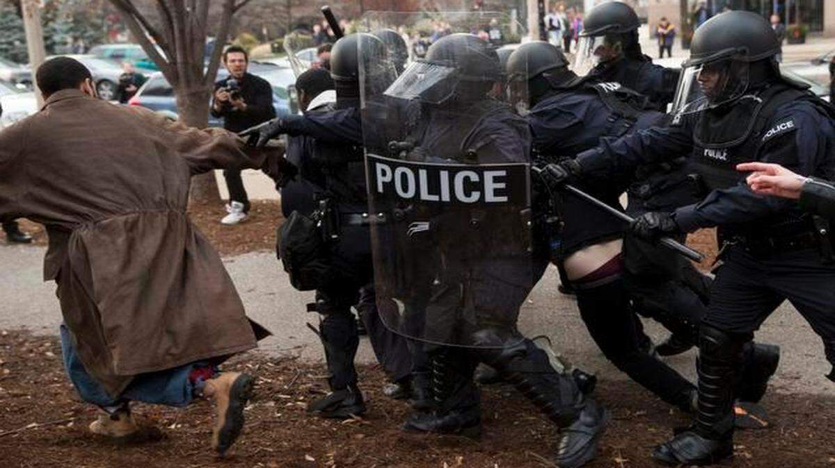 
After months of violence that ensued following the fatal shooting of Michael Brown, a $4.75 million federal grant will support the National Initiative for Building Community Trust and Justice, a program to “enhance procedural justice, reduce bias and support reconciliation,” according to officials who rolled out the program’s details Mar. 12, 2015. In this photo, police officers charge demonstrators protesting in the week following the grand jury’s decision not to indict Ferguson Police Officer Darren Wilson in the fatal shooting of Michael Brown, in downtown St. Louis, Mo., Nov. 30, 2014.

