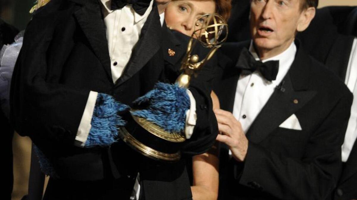 Bob McGrath, right, looks at the Cookie Monster as the accept the Lifetime Achievement Award for ‘Sesame Street’ at the Daytime Emmy Awards on Aug. 30, 2009, in Los Angeles.