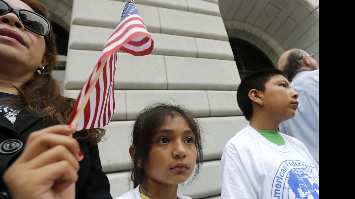 
Ebenyn Roca, 9, of Miami, holds an American flag participates in a rally led by the New Orleans Worker Center for Racial Justice and the Congress of Day Laborers, outside the U.S. Fifth Circuit Court of Appeals in New Orleans, Friday, April 17, 2015. 
