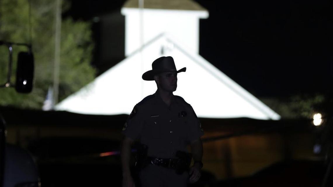 A law enforcement official walks past the First Baptist Church of Sutherland Springs, the scene of a mass shooting, Sunday, Nov. 5, 2017, in Sutherland Springs, Texas.