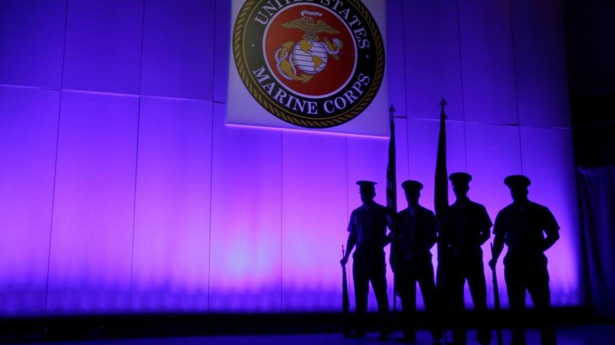 FILE – A Marine Corps Color Guard stands under a Marine emblem in Jupiter, Fla., May 5, 2014. The Naval Criminal Investigative Service is investigating reports that some Marines shared naked photographs of female Marines, veterans and other women on a Facebook page, some of which were taken without the women’s knowledge. Marine Corps Commandant Gen. Robert B. Neller called the online activity "distasteful" and says it shows an "absence of respect."