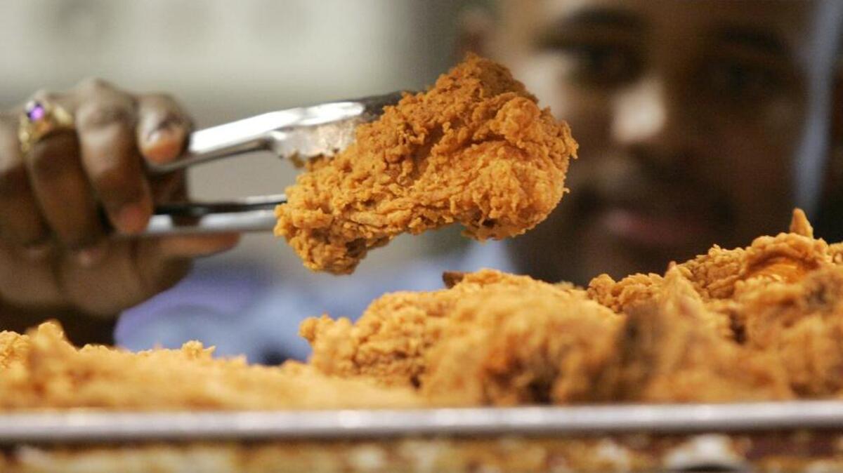 FILE - In this Monday, Oct. 30, 2006 file photo, a Kentucky Fried Chicken employee uses tongs to hold up an sample of the company's trans fat-free Extra Crispy fried chicken in New York.