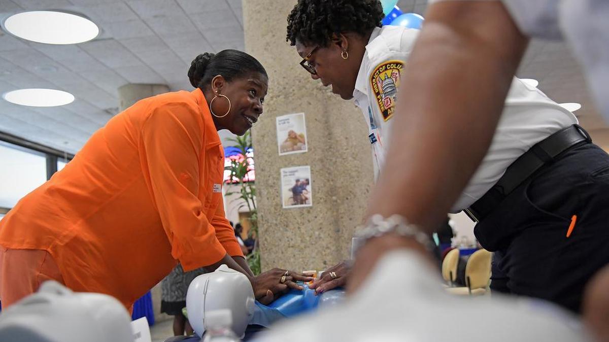 Elvie Thompson, 58, gets a hands on CPR training session with paramedic Shelia Henderson at a health fair in Washington, D.C. Thompson learned CPR years ago when she was in the Army and quickly picked up the rhythm of the new technique, called “Hands-Only CPR.”
