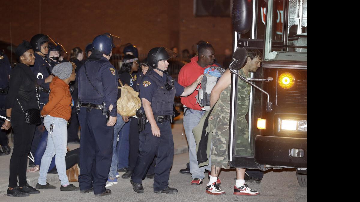 
Protesters are escorted to a bus for transport after getting arrested after protesting the acquittal of Cleveland police officer Michael Brelo May 23, 2015, in Cleveland. The acquittal came at a time of nationwide tension among police and black citizens punctuated by protests over the deaths of black suspects at the hands of white officers — and following a determination by the U.S. Department of Justice that Cleveland police had a history of using excessive force and violating civil rights.
