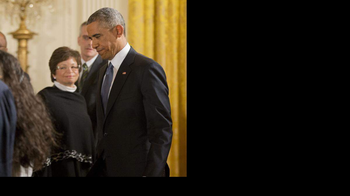 
President Barack Obama walks in for the start of his news conference in the East Room of the White House, on Nov. 5, 2014, in Washington. In the back are White Senior Adviser Valerie Jarrett, left, and White House Chief of Staff Denis McDonough.
