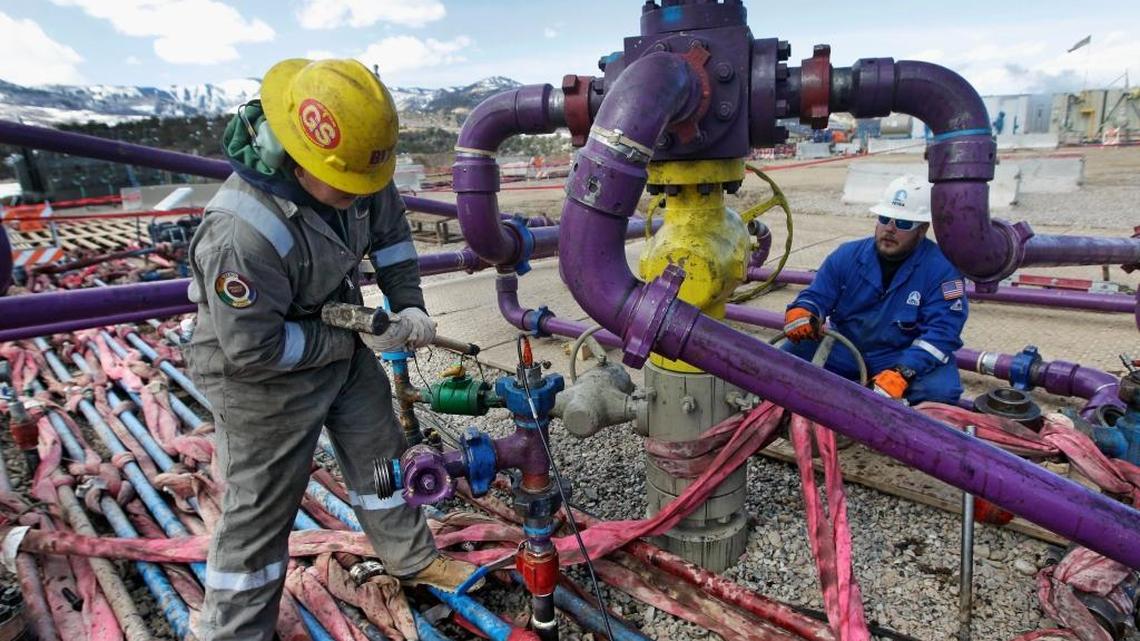 Workers tend to a wellhead at a hydraulic fracturing operation outside Rifle, in western Colorado, in March 2013.