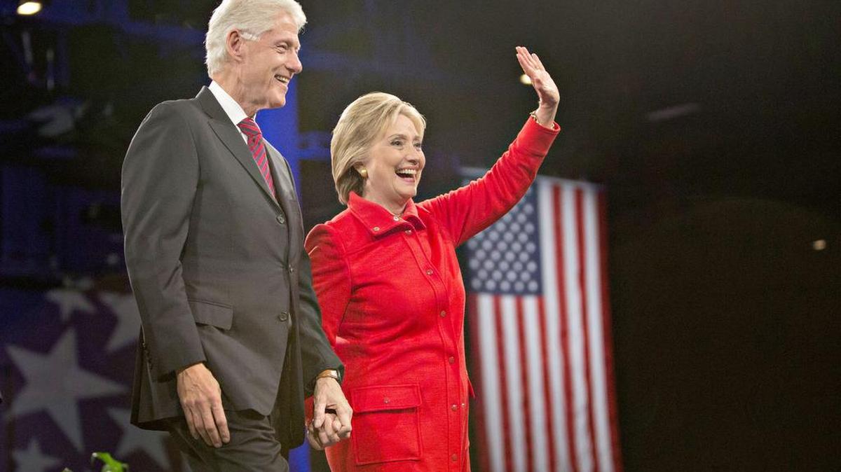 Hillary Clinton stands on stage with her husband, former President Bill Clinton, at the conclusion of the Jefferson-Jackson Dinner in Des Moines, Iowa, on Saturday.