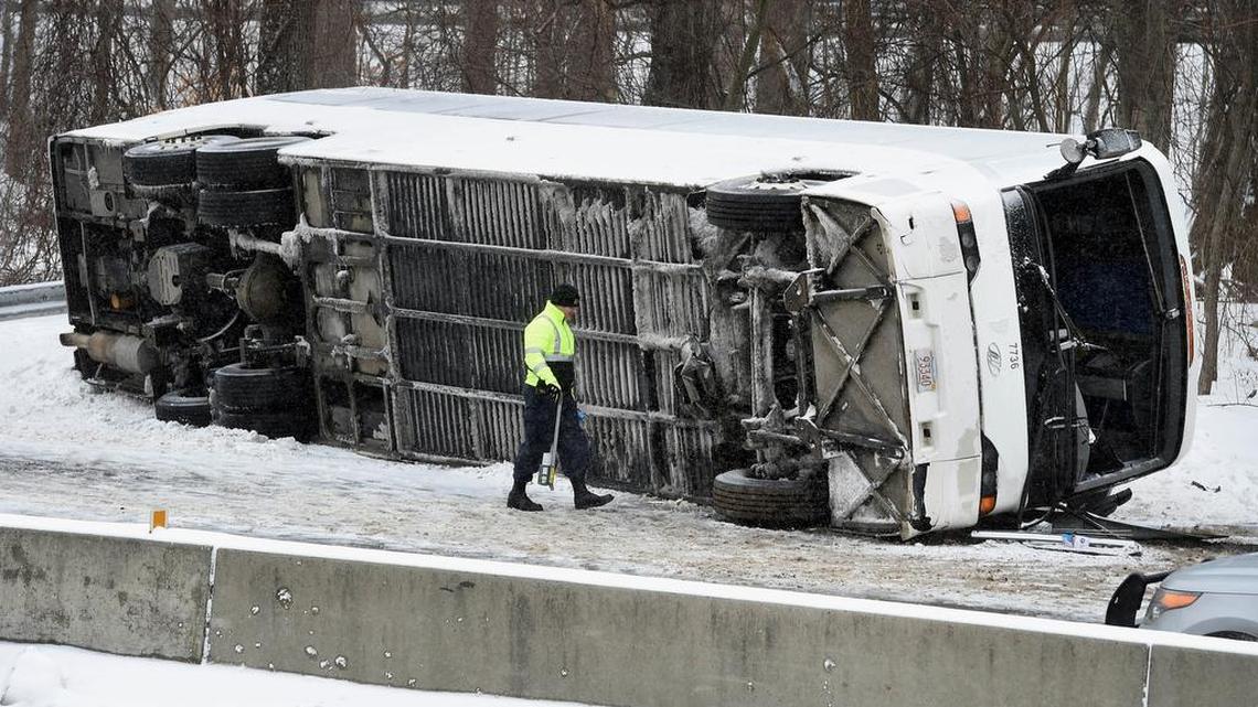 A Connecticut State Police officer investigates an overturned casino-bound tour bus on I-95 North near exit 61 in Madison, Conn., Monday, Feb. 8, 2016. The charter bus accident has left at least 30 people injured, several critically, and closed the northbound side of Interstate 95 in Madison.