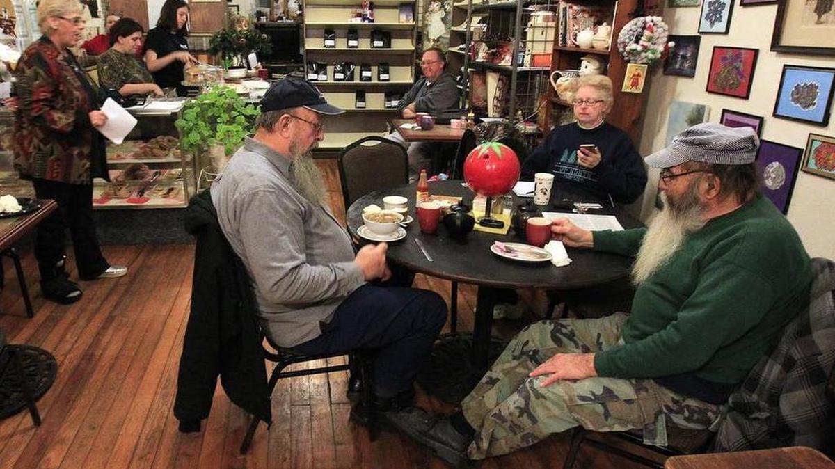 Maggie Boone Tribout (standing at left) is a co-host of the "Death Cafe" meetings, which are held in Belleville at the Miscellanea House coffehouse. Here, she speaks to those gathered to discuss death and dying in an informal setting. Eating cake during the discussions is one of the traditional prerequisites.