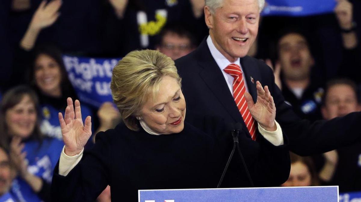 Democratic presidential candidate Hillary Clinton reacts as former President Bill Clinton smiles at her New Hampshire presidential primary campaign rally, Tuesday, Feb. 9, 2016, in Hooksett, New Hampshire.