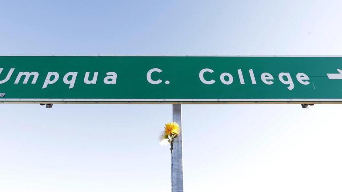 
A flower is posted on a direction sign to Umpqua Community College, Friday, Oct. 2, 2015, in Roseburg, Ore. Armed with multiple guns, Chris Harper Mercer, walked into a class at the community college, Thursday, and opened fire, killing several and wounding others. 
