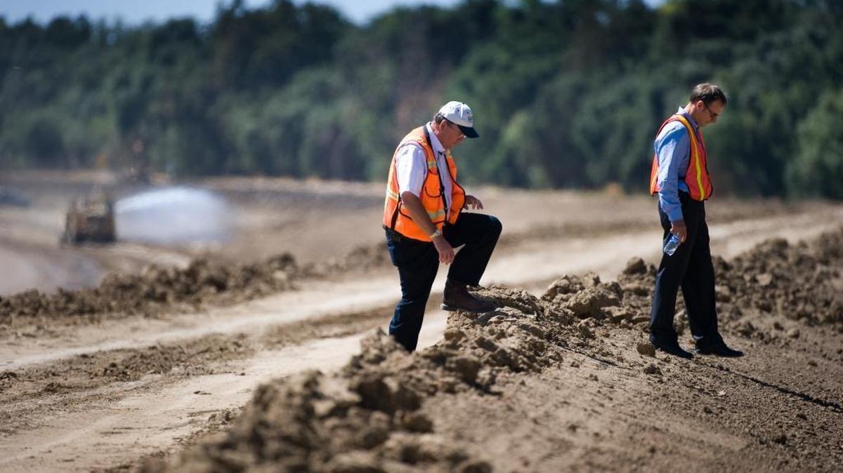 John Bassett, Director of Engineering (left) and Peter Buck, Natural Resources Supervisor for the Sacramento Area Flood Control Agency, make their way over a levee under construction in September 2010.