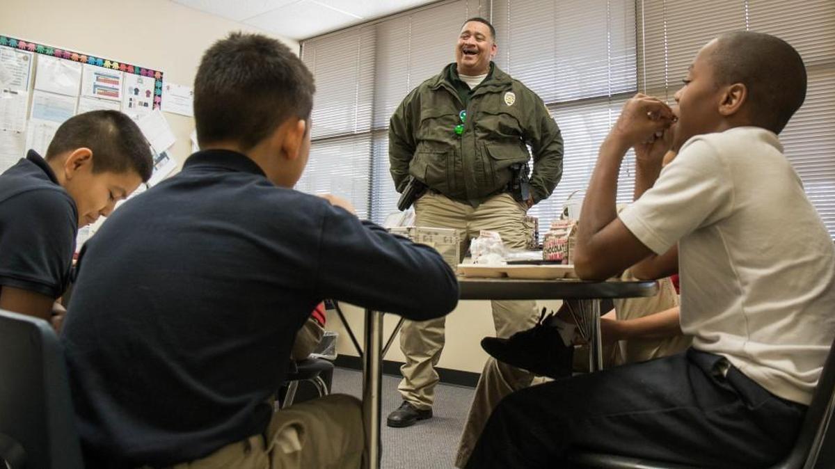 Officer Chris Robinson laughs as he calls out one of the Anderson Elementary boys he mentors. Robinson has been mentoring five boys at the school, trying to build character. (Dec. 13, 2016)