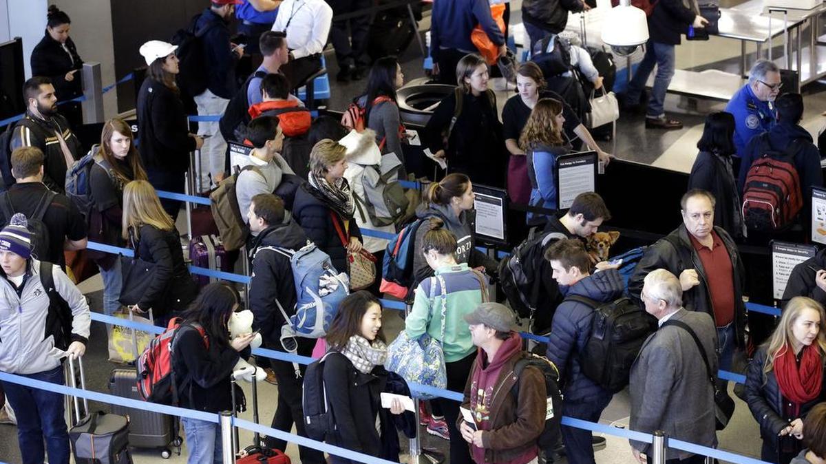 Travelers line up at a security checkpoint area at O’Hare International Airport on Sunday in Chicago. Tens of millions of Americans returning home after the long Thanksgiving holiday weekend Sunday have cooperative weather and mostly efficient airport operations to thank for smooth traveling conditions.