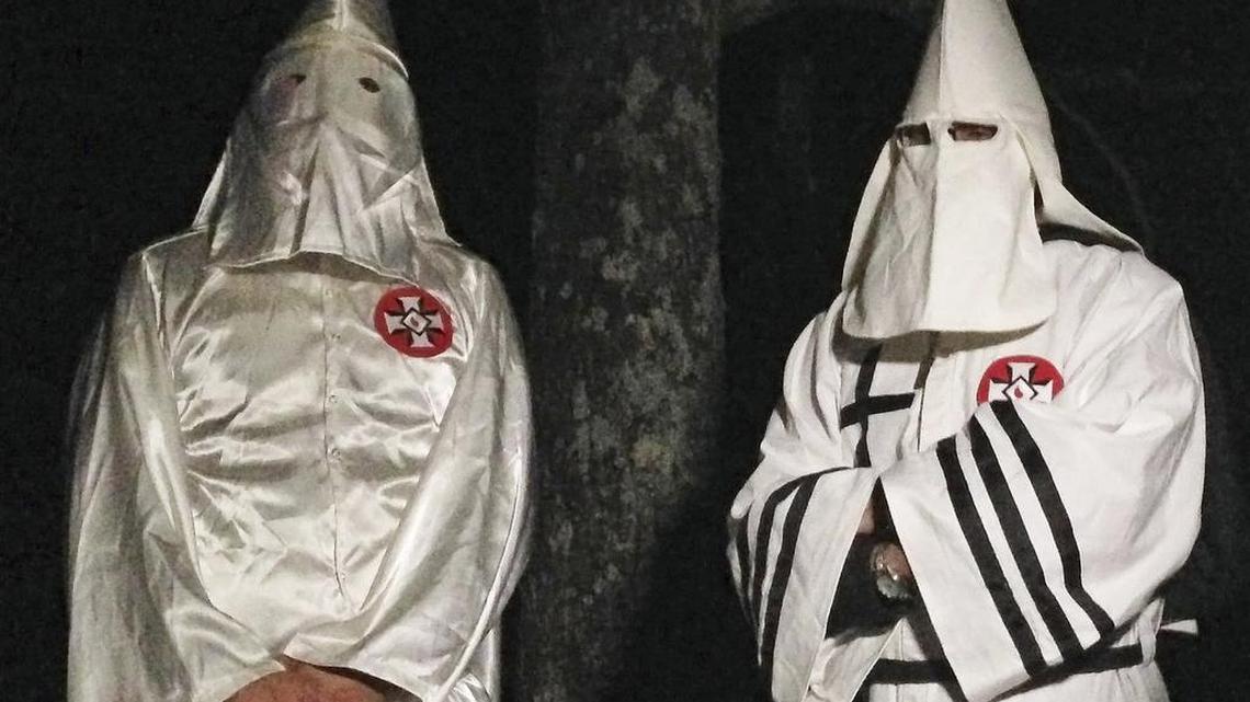 Masked Ku Klux Klansmen stand on a muddy dirt road during an interview Friday near Pelham, N.C. The KKK and other white extremist groups don't like being called "white supremacists," a phrase that dates to the earliest days of white racist movements in the United States.