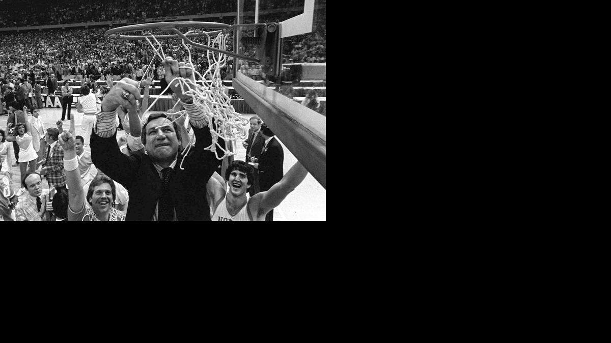 
University of North Carolina coach Dean Smith cuts the net as happy players and fans cheer after the Tar Heels defeated Georgetown for the NCAA Championship in 1982.

