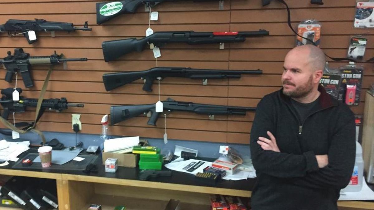 Firearms salesman Nathan Williams, 37, of Albuquerque, attends to customers at The Outdoorsman gun shop in Santa Fe, N.M., on Jan. 5, 2017.