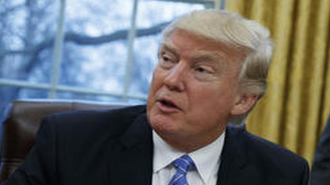 President Donald Trump signs an executive order to withdraw the U.S. from the 12-nation Trans-Pacific Partnership trade pact Monday.