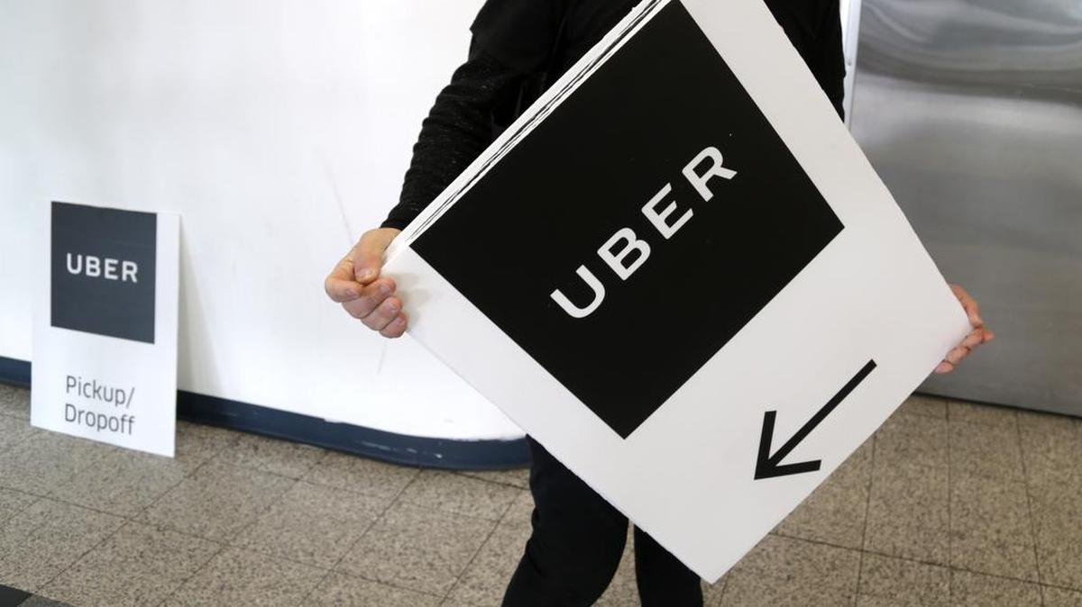 An Uber representative put up signs at LaGuardia Airport in New York, Wednesday, March 15, 2017.
