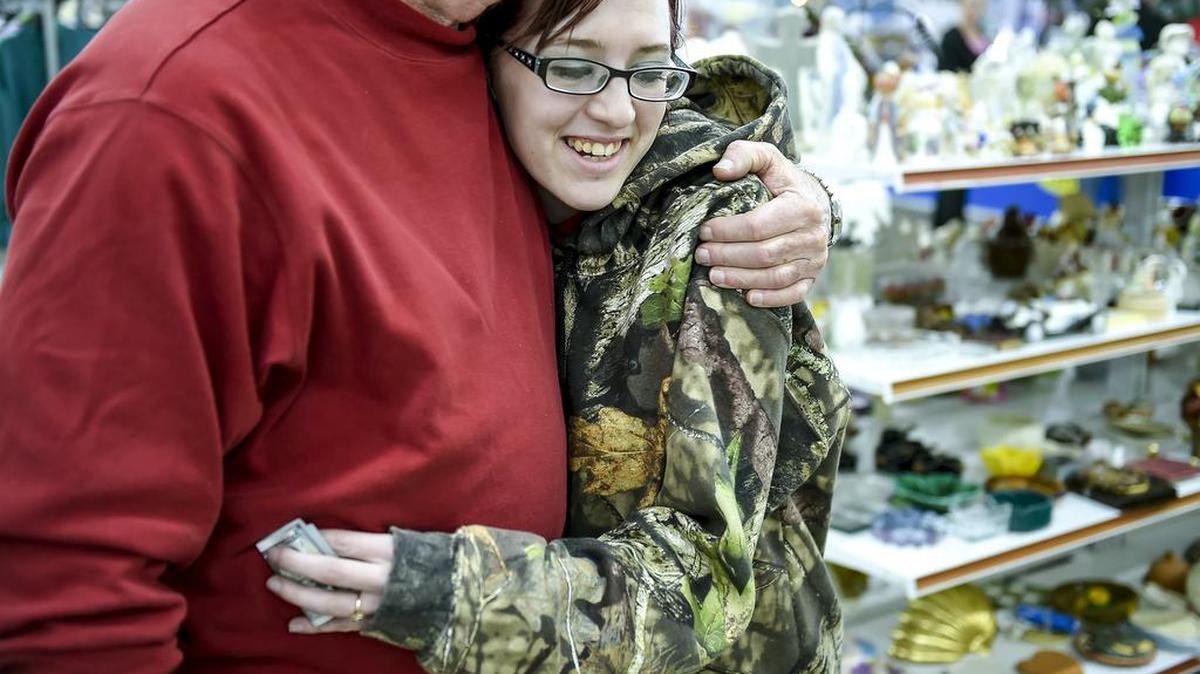 Elizabeth Bowman, an employee at the Disabled American Veterans Red Racks Thrift Store, hugged Secret Santa after receiving a $100 bill in thanks for the work she does in the thrift store. Secret Santa traveled across Independence on Thursday to spread cheer.