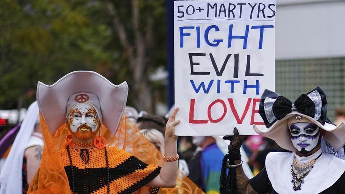 Participants in the gay pride parade in West Hollywood, California, hold a sign showing their support to the victims the shooting in Orlando.
