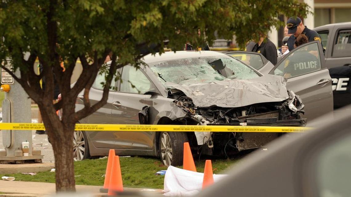 Police investigate a damaged car after the vehicle crashed into a crowd of spectators during the Oklahoma State University homecoming parade, causing multiple injuries, on Saturday, Oct. 24, 2015 in Stillwater, Oka.