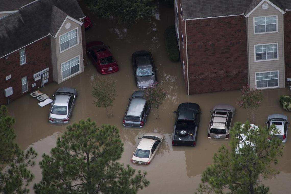 Swamped cars surround a residential area in west Houston. Early analyses indicate that Harvey and the flooding that followed could be the most destructive event ever for automobiles in the United States.