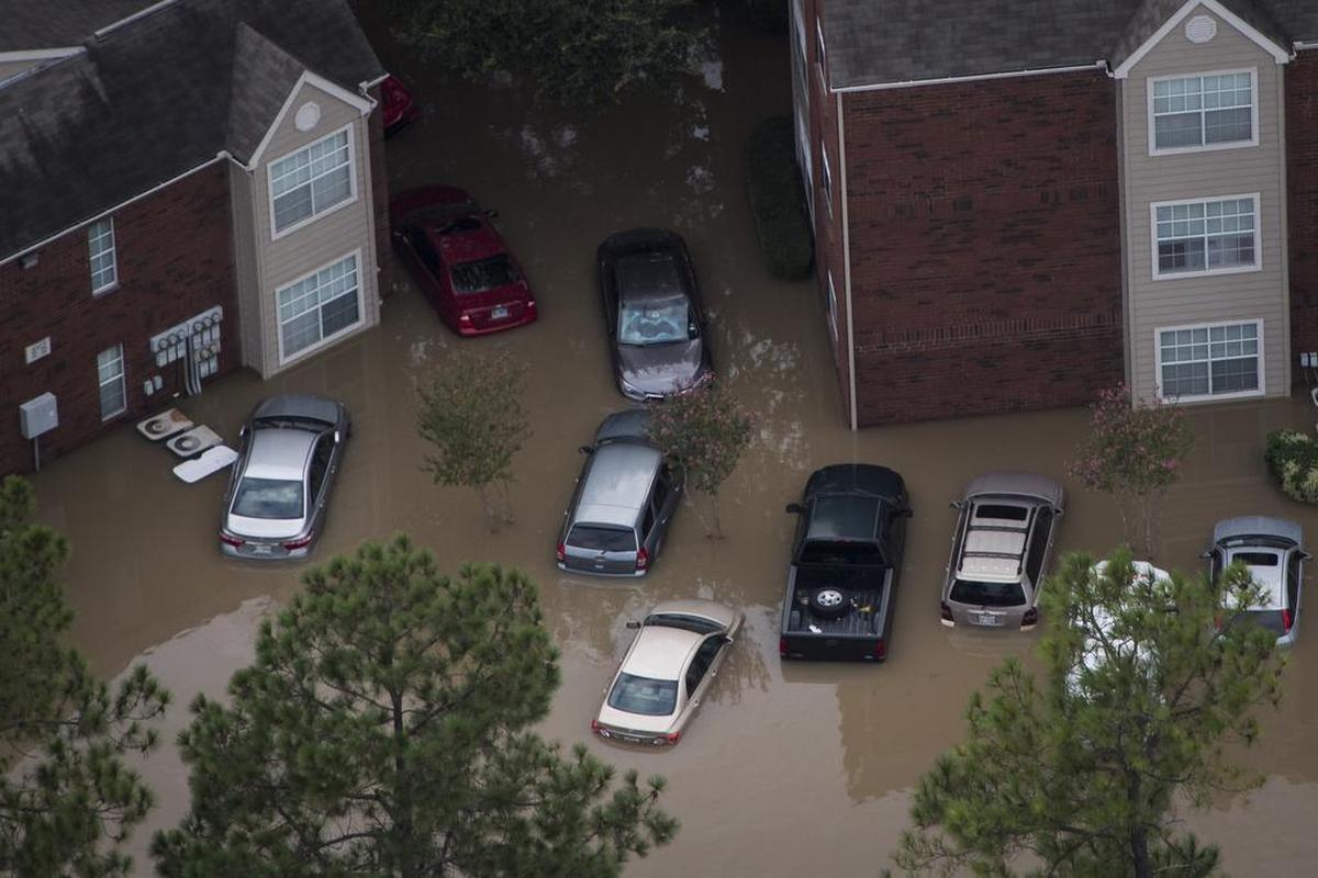 Swamped cars surround a residential area in west Houston. Early analyses indicate that Harvey and the flooding that followed could be the most destructive event ever for automobiles in the United States.