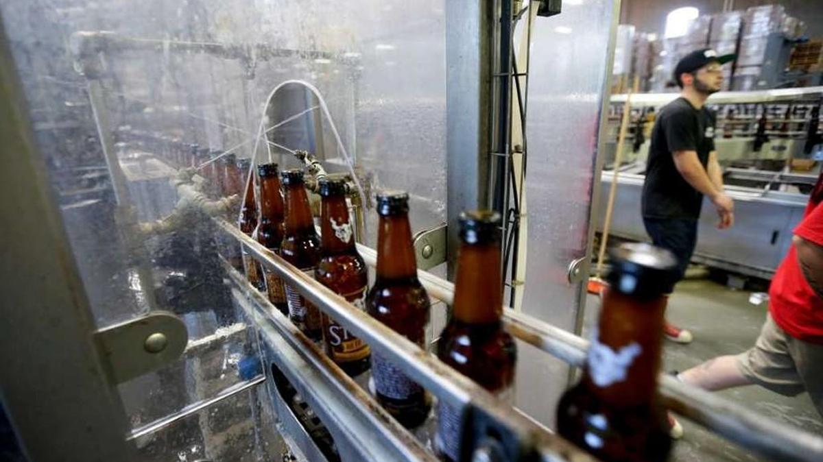Bottles of beer are cleaned using recycled non-potable water during the bottling process at Stone Brewing Co. on Wednesday, Sept. 30, 2015, in Escondido, Calif. In an effort to reduce water use, the brewery is spending $1 million on expanding its $8 million wastewater treatment system installed in 2008, and aims to use only three gallons of water for every gallon of beer it produces. The treated water is used to clean equipment.