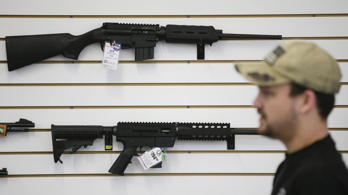 A sales associate walks past semiautomatic rifles at Bullseye Sport gun shop in Riverside, Calif. The massacre at Sandy Hook Elementary School in which a mentally disturbed young man killed 26 children and teachers galvanized calls across the nation for tighter gun controls. But in the three years since, many states have moved in the opposite direction, embracing the National Rifle Association’s response that more “good guys with guns” are what’s needed to limit the carnage of mass shootings.
